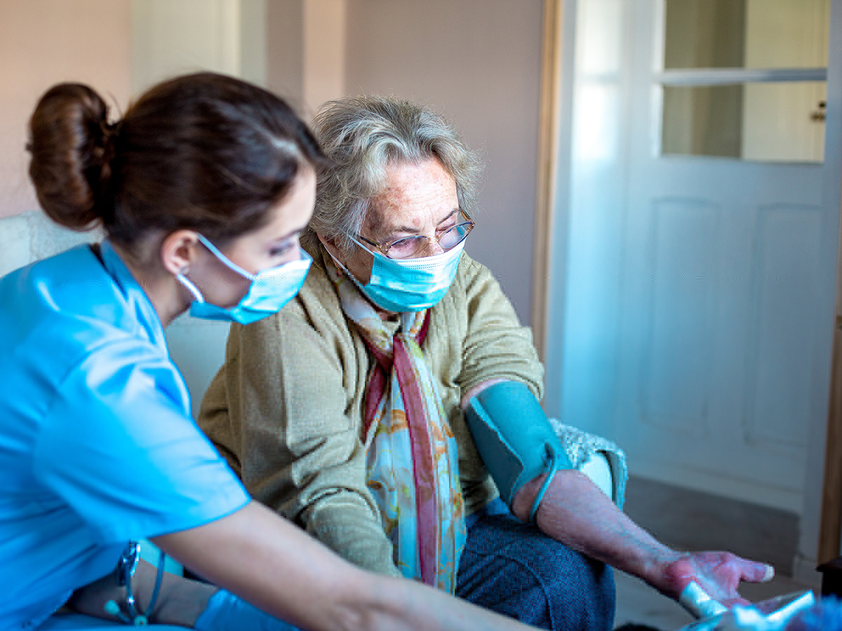 Enfermera toma la tensión una mujer en una residencia de mayores