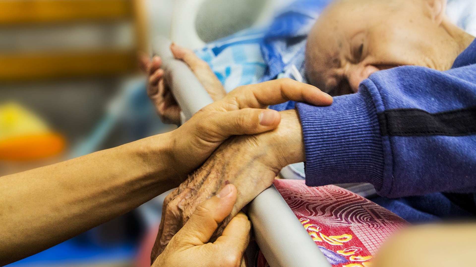 Una enfermera sostiene la mano de un anciano