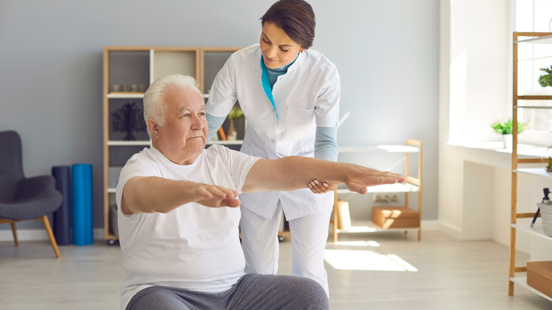 Una fisioterapeuta atiende a una persona mayor en su consulta
