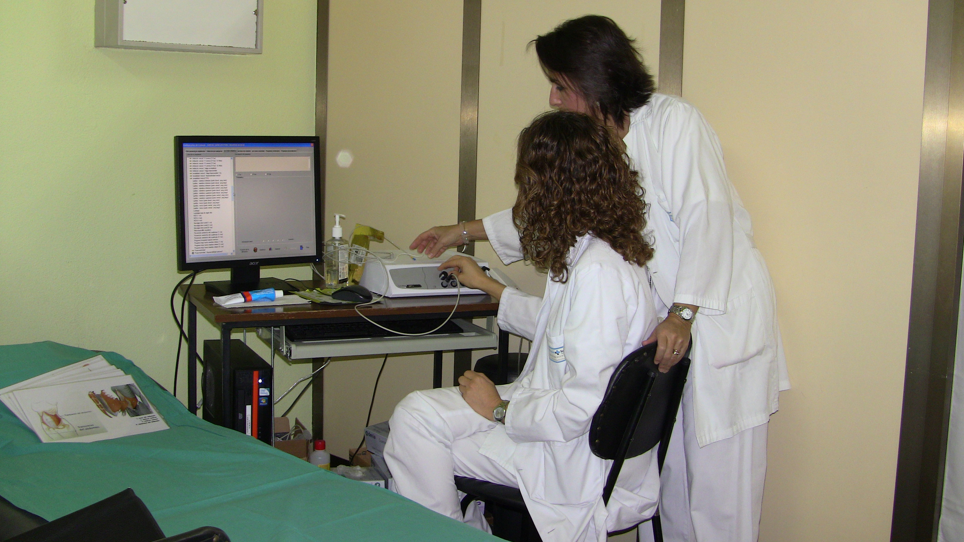 Imagen de dos fisioterapeutas trabajando en una consulta. 